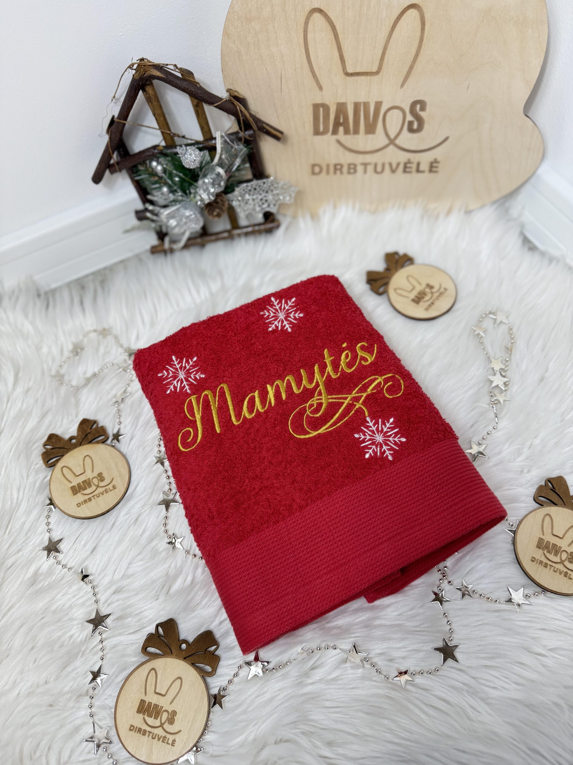 Raudonas siuvinėtas rankšluostis dėžutėje su užrašu „Mamytės“, papuošta snaigėmis.